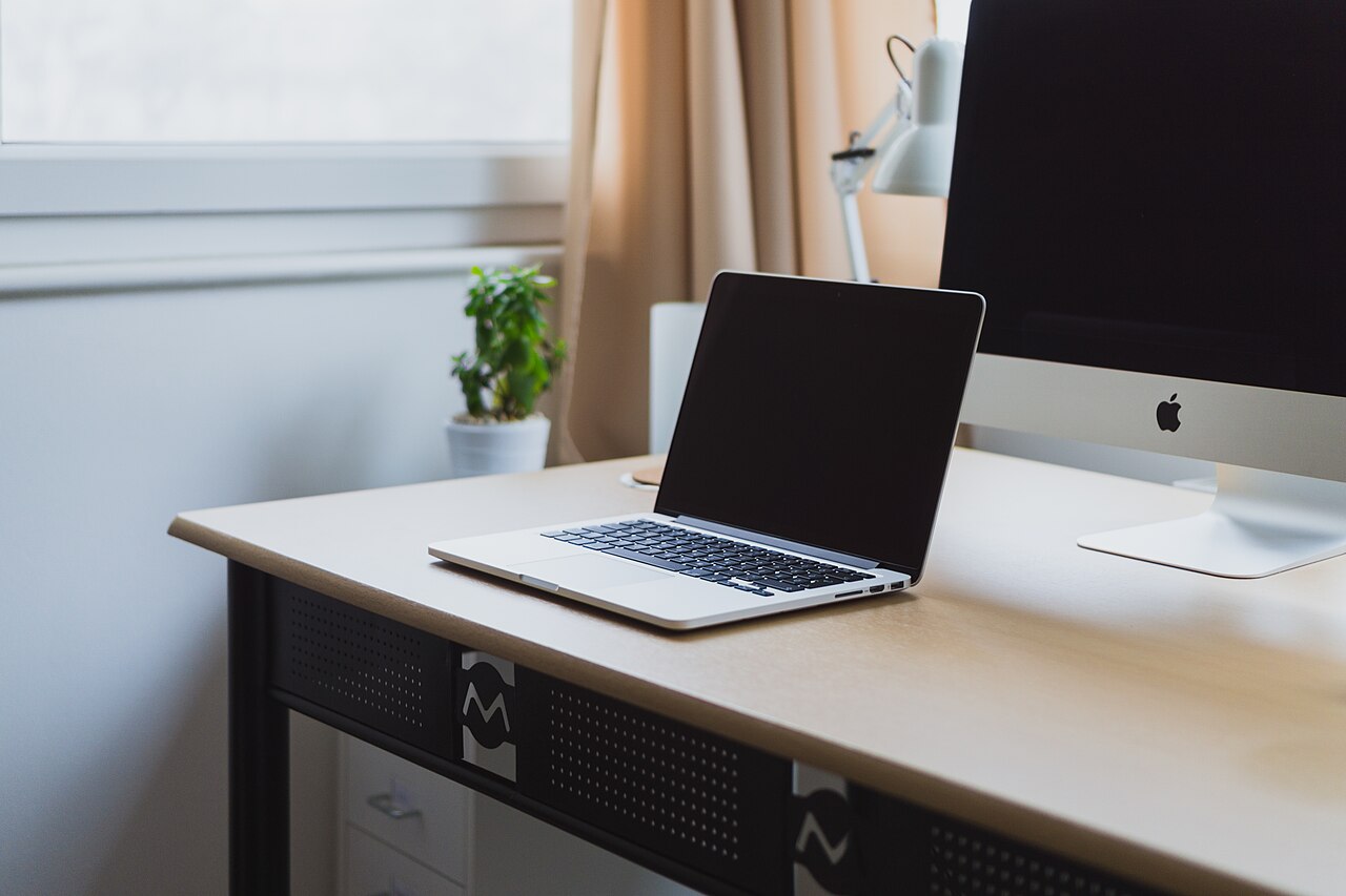 A laptop and desktop computer on a tidy desk; a representative workspace. File photo; not the reported event.